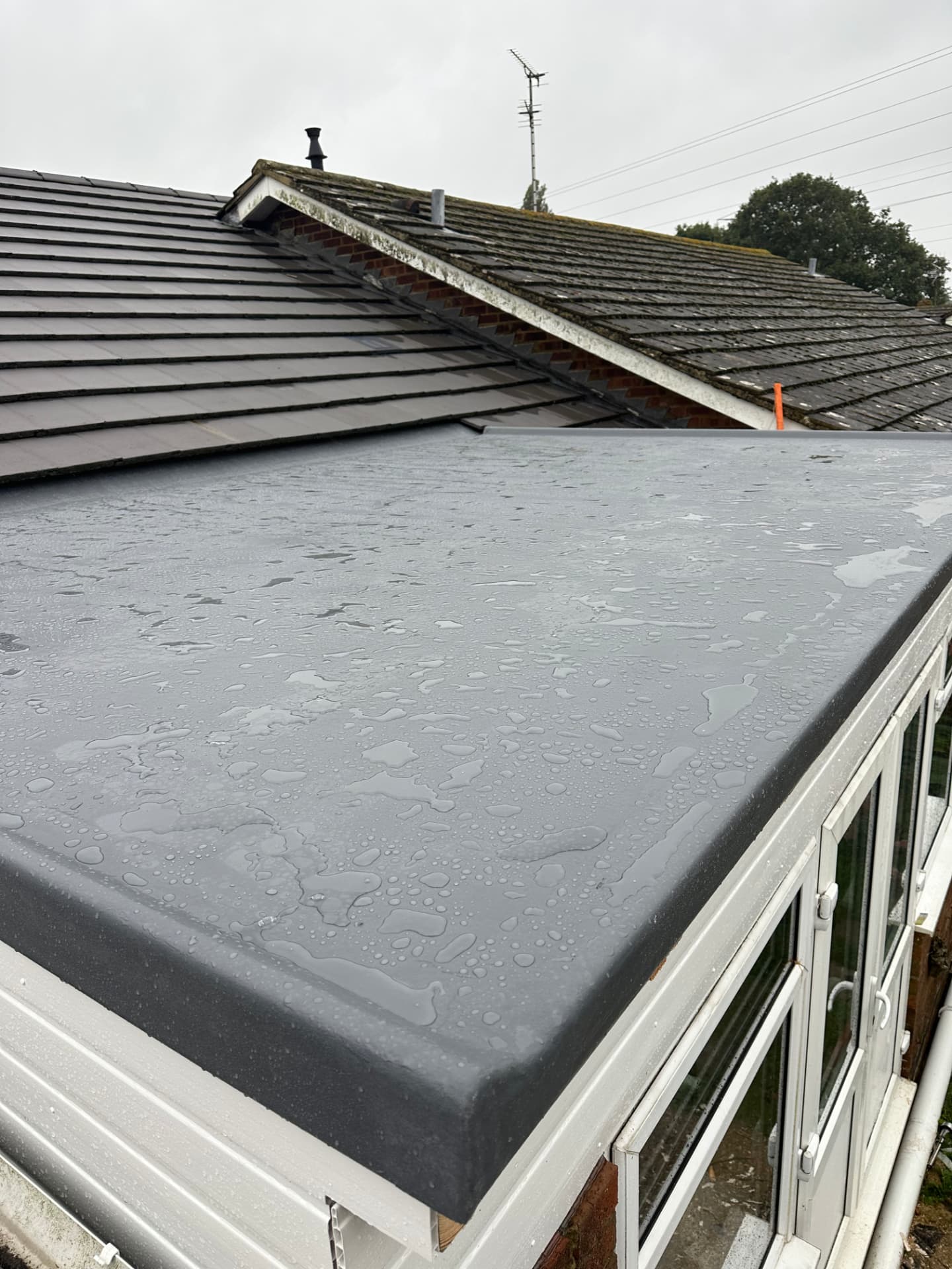 Grey GRP flat roof over a conservatory
